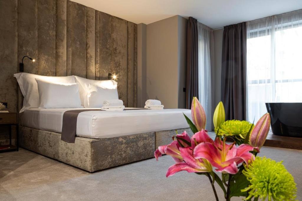 a bedroom with a bed and flowers in a room at Abrazo Sofia Hotel by HMG in Sofia