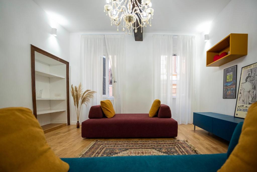 a living room with a red couch and a mirror at Splendido appartamento nel centro di Roma, Monti in Rome