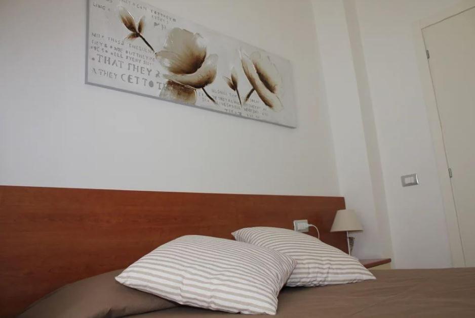 a bed with two pillows and a poster on the wall at Hotel Villa Argentina in Riomaggiore