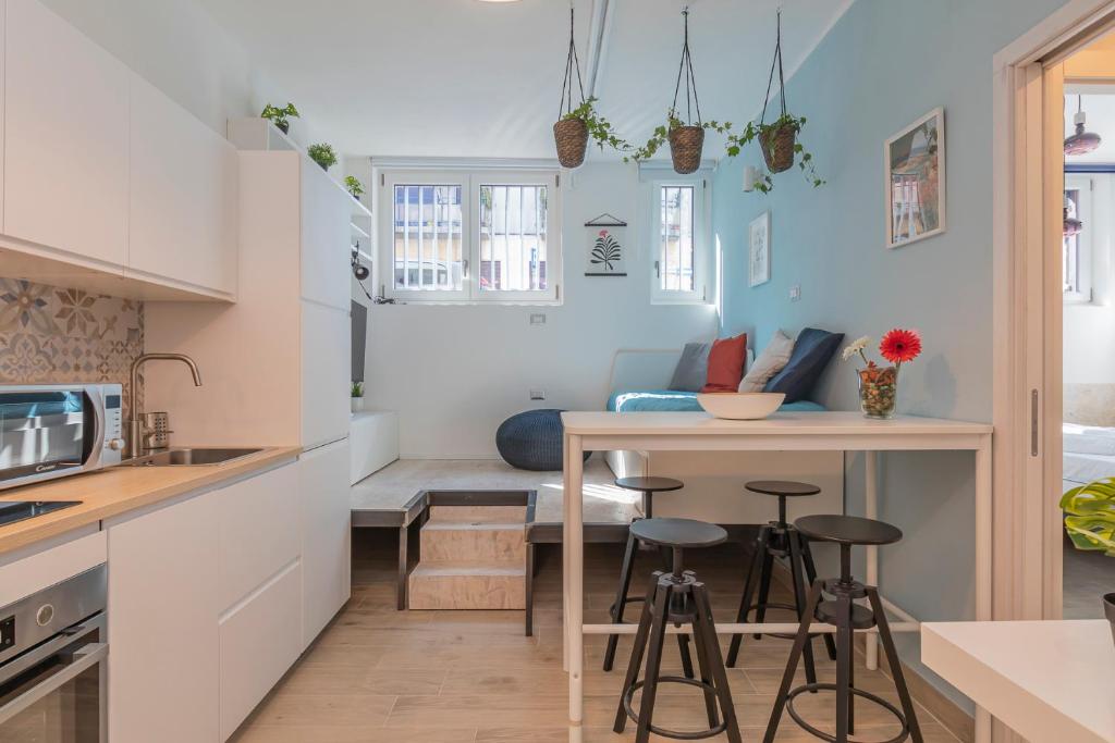 kuchnia ze stołem, stołkami i kanapą w obiekcie [Sweet apartment] - Grazioli 2 w Mediolanie