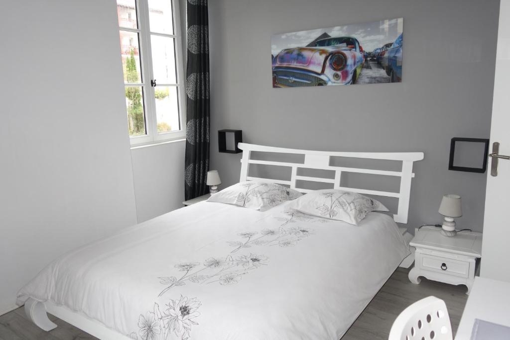 um quarto com uma cama branca e uma janela em Le Petit Nid Douillet de Jéjé em Baiona