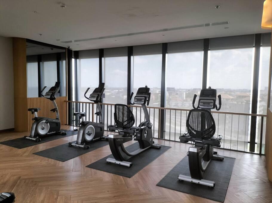 a gym with treadmills and ellipticals in a building at Two bedroom condo with rooftop pool in Ban Talat Rangsit