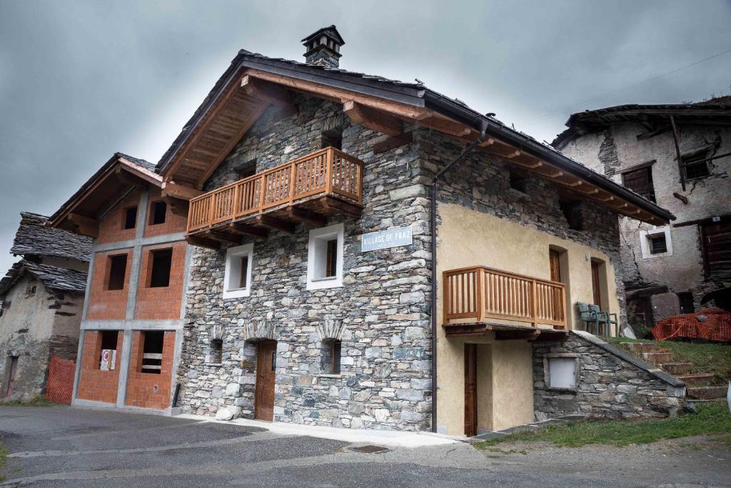 un edificio con un balcón en el lateral. en Le Grand Coeur - Monolocale di montagna con stufa, en Nus