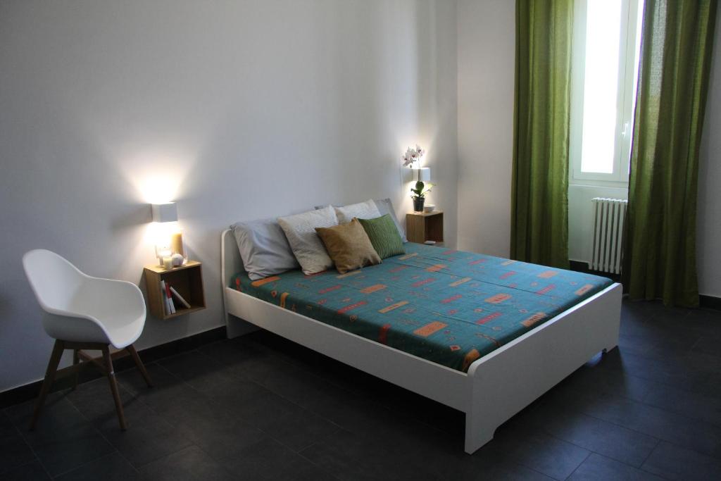 a bedroom with a bed and a chair and a window at Ex Dogana Home in Fiumicino