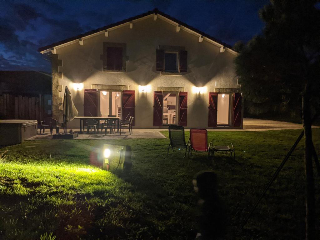 ein Haus mit Lichtern am Vorgarten in der Nacht in der Unterkunft au gite de la cascade in Le Grand Serre
