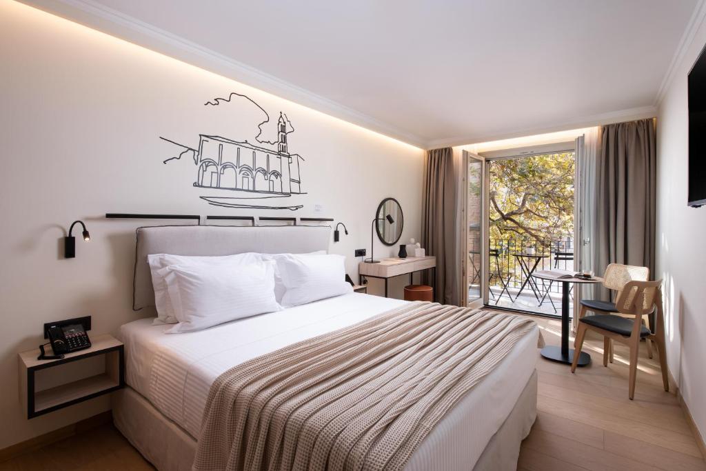 a bedroom with a large bed and a balcony at Epoch House & The Orange Shop - Adults Only in Nafplio