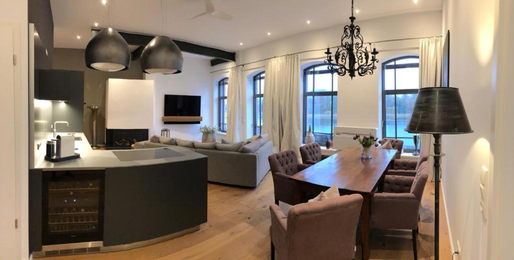 a kitchen and living room with a table and chairs at Loft mit Seeblick in Malchow
