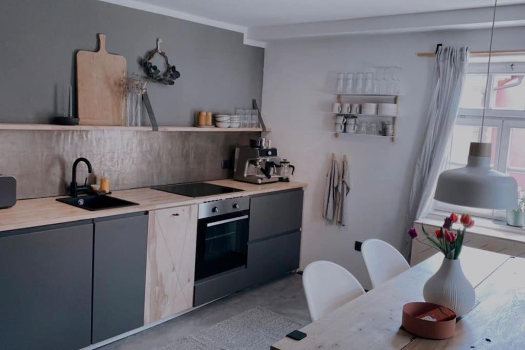 a kitchen with a sink and a stove and a table at Altstadtjuwel in Cadolzburg- Hidden by Feingemacht in Cadolzburg