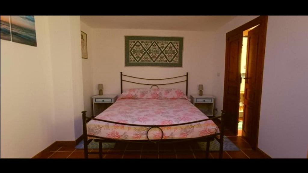 a bedroom with a bed with a pink bedspread at Casa Sartiglia in Oristano