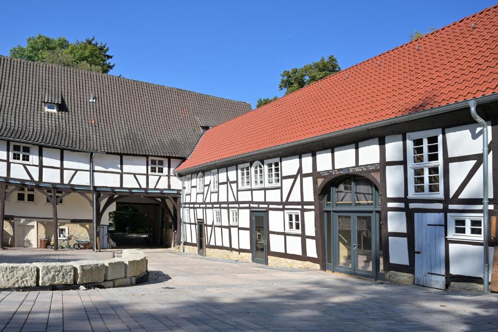 un edificio blanco y negro con techo rojo en Gut Junkernhof, en Calden