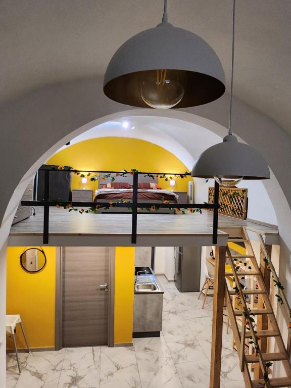 a kitchen with yellow and yellow walls and two pendant lights at Chimera House in Catania