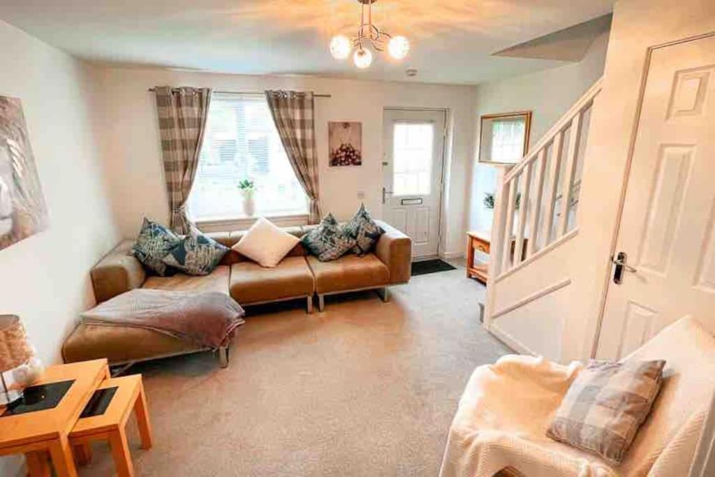 a living room with a couch and a window at Loch Leven Getaway - 2 bed house in Kinross