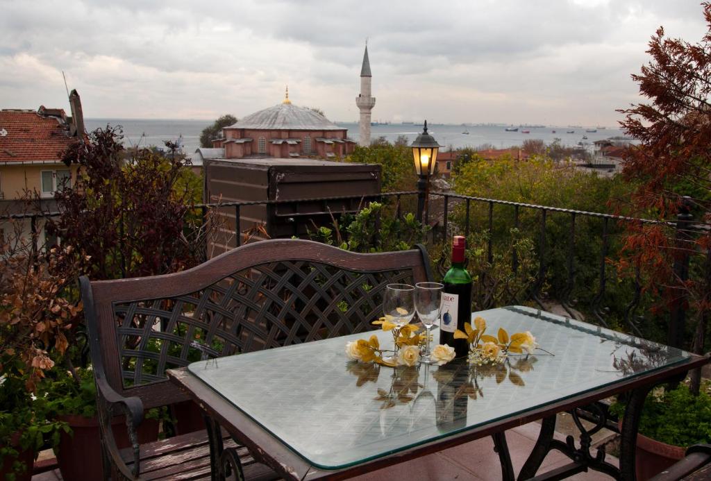 a table with a bottle of wine and flowers on a balcony at Sultanahmet Suites in Istanbul