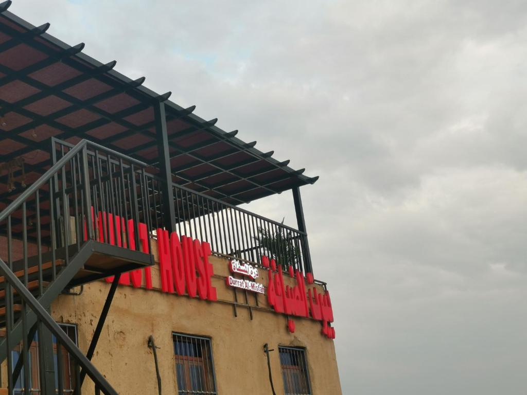 a building with a balcony on top of it at Durrat Al-Misfah Guest House in Misfāh