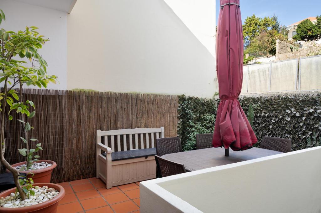 une terrasse avec un parasol, une table et des chaises dans l'établissement Refugio, à Porto