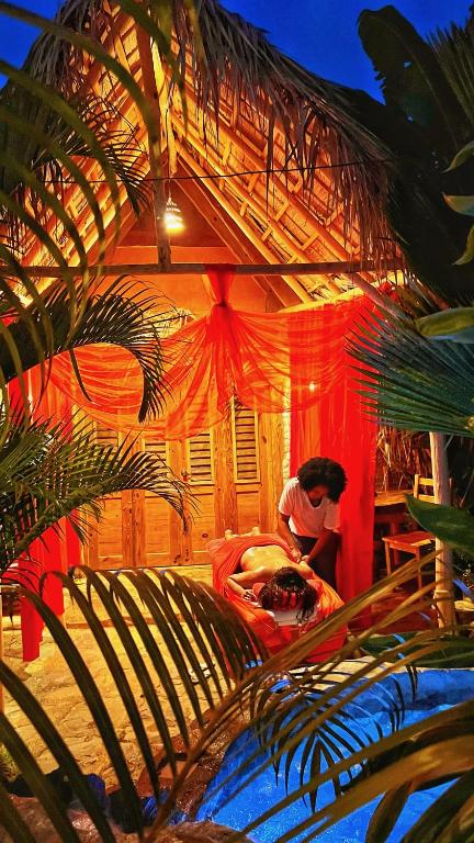 a man laying on a bed in a room with at CHALET TROPICAL Hotel & Restaurant-Pizzeria in Las Galeras