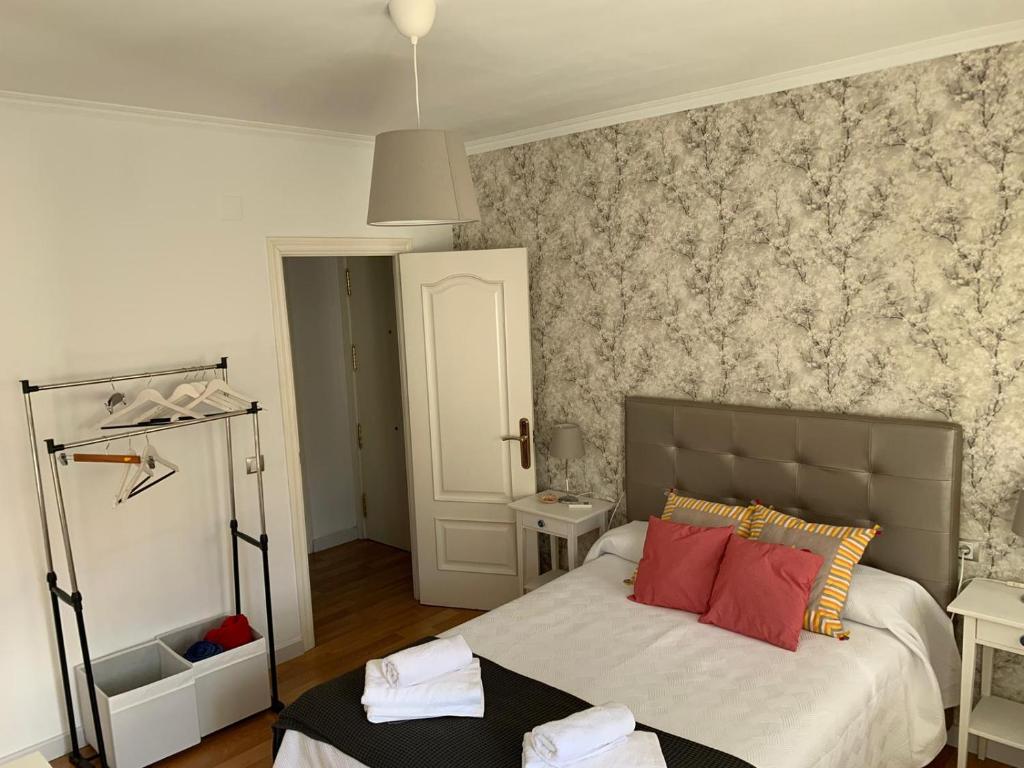 a bedroom with a bed with red pillows on it at Acogedor apartamento en pleno corazón de Triana in Seville