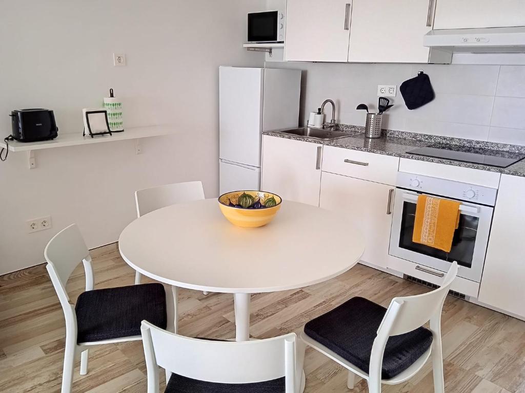 a white kitchen with a white table and chairs at Blue View Hermoso Apartamento Remodelado Ubicación Ideal in Costa Teguise