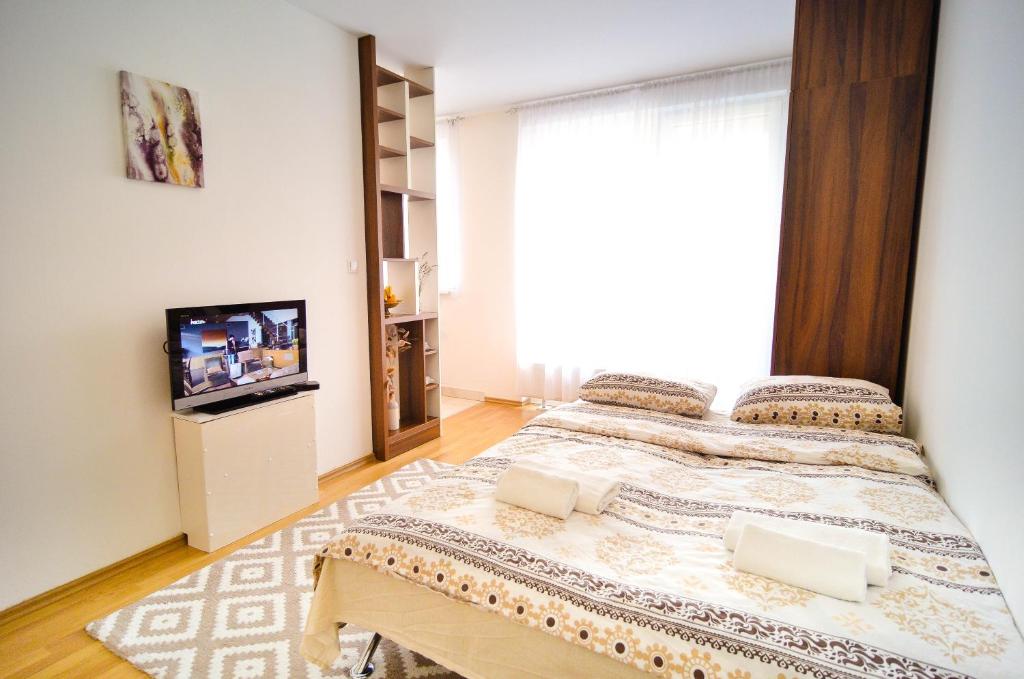 a bedroom with a large bed and a television at Miljacka in Sarajevo