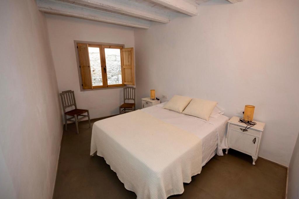 a bedroom with a white bed and a window at Cal Torrentó Apartaments in Balaguer