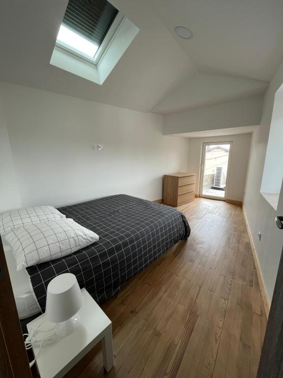 a bedroom with a bed and a table and a window at Superbe maison de ville, rénovée à 15 min de Lyon in Saint-Symphorien-dʼOzon