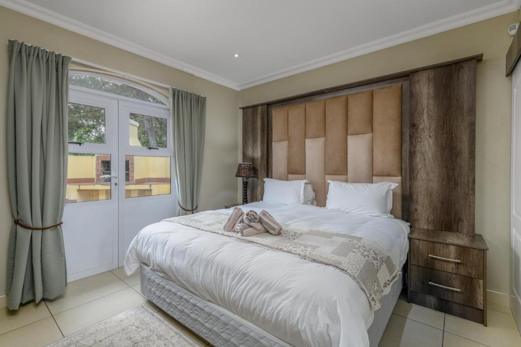 een slaapkamer met een groot bed met twee schoenen erop bij Caribbean Estates Villa Caylee - Ultra-Luxurious - Rimas Interiors Designs - Private Beachfront Escape - Premium serviced for 8 Guests in Port Edward