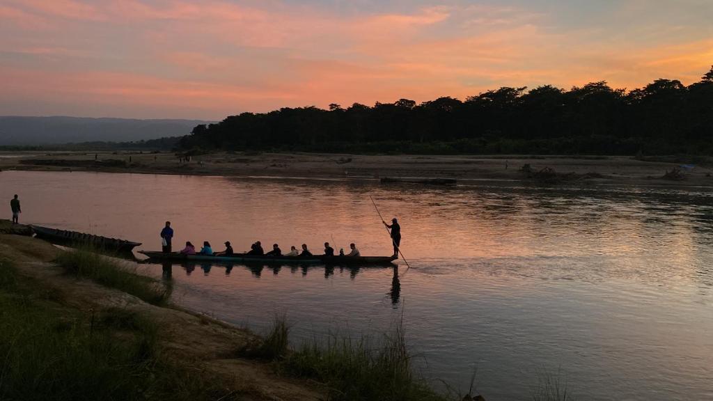 a group of people on a boat in the water at Hotel Sauraha Gaida House in Chitwan