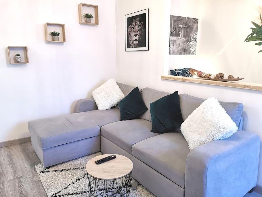 uma sala de estar com um sofá azul e uma mesa em Superbe appartement centre ville proche des pistes em Morez