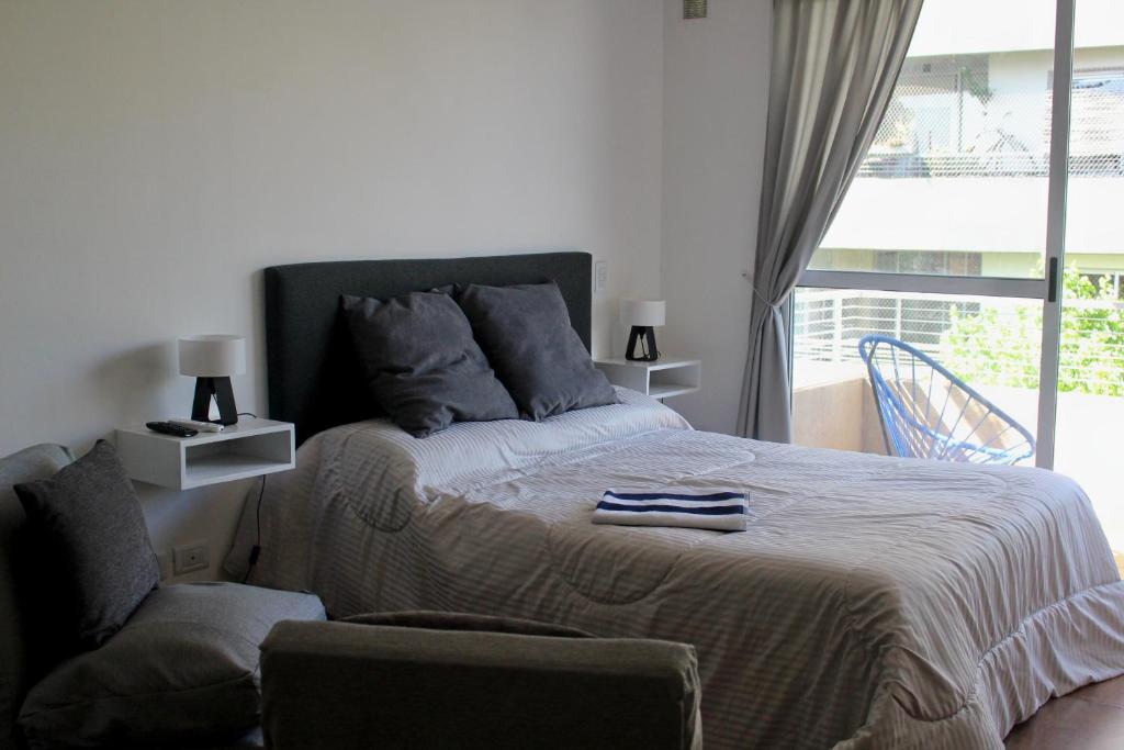 1 dormitorio con 1 cama, 1 silla y 1 ventana en AA Naon apart en Buenos Aires