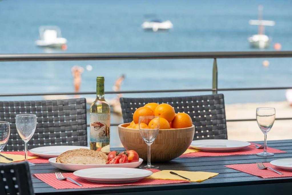 a table with a bowl of fruit and a bottle of wine at S'Embat sea views in Alcudia