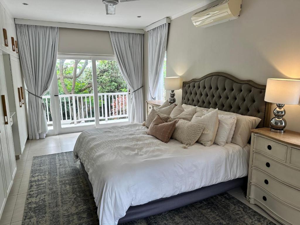 sypialnia z dużym łóżkiem i balkonem w obiekcie Off Shore Ballito w mieście Ballito
