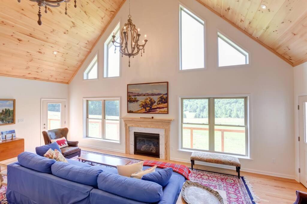 - un salon avec un canapé bleu et une cheminée dans l'établissement Bovina Mountain Meadow, à Bovina Center