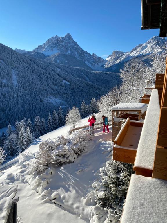 two people skiing down a snow covered mountain at Hotel Almhof in San Candido