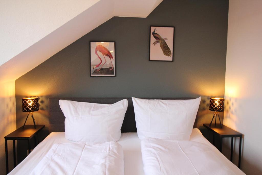 a bedroom with a bed with two lamps and pictures on the wall at Stylische Ferienwohnung mit Ausblick in Haslach