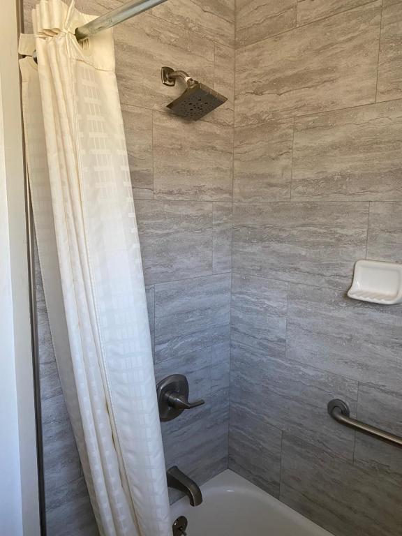 doccia con vasca e tenda da doccia di Western Holiday Lodge a Three Rivers