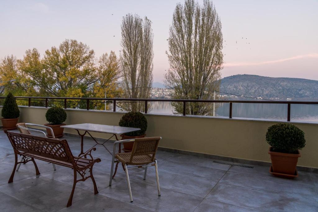 a patio with a table and chairs on a balcony at view kastoria in Kastoria