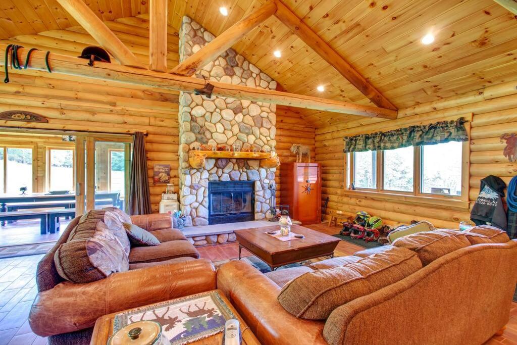 a living room with couches and a stone fireplace at Bull Run Ranch in Margaretville