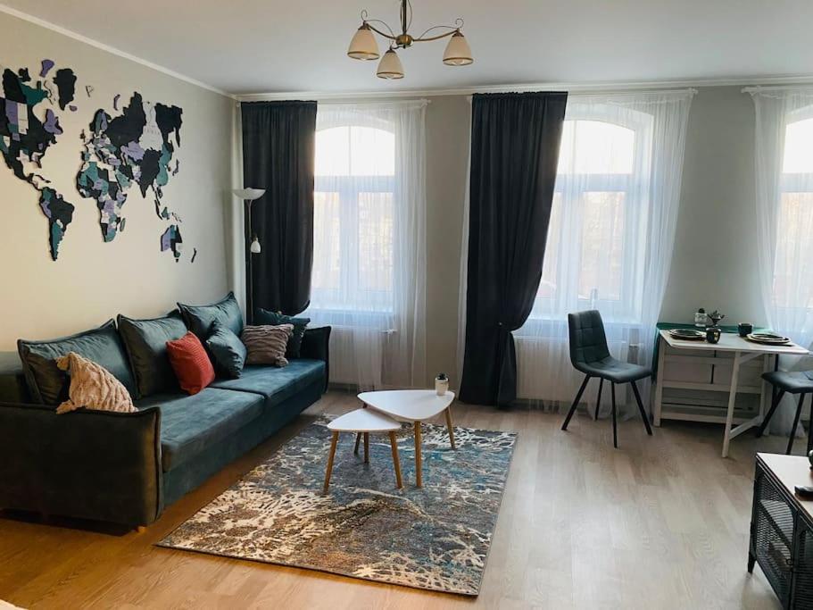 a living room with a couch and a world map on the wall at 1-bedroom loft in Siena Tirgus in Rīga