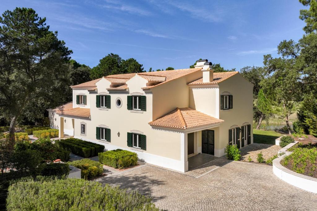 una vista exterior de una casa con patio en Villa at Quinta do Perú Golf and Country Club en Quinta do Conde