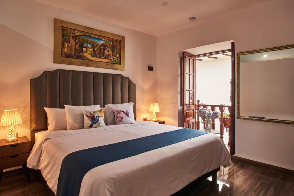 a bedroom with a large bed and a mirror at Hotel Dordéan Casona Boutique in Chachapoyas