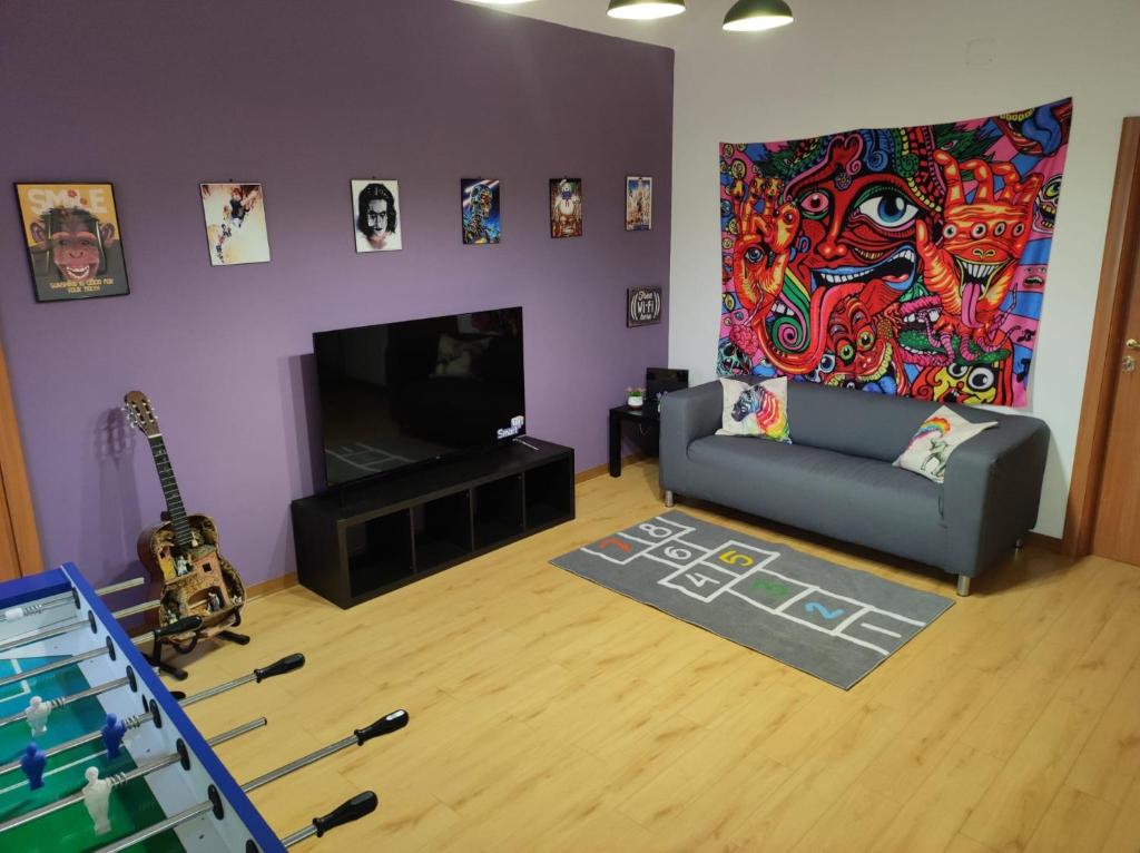 ein Wohnzimmer mit einem Sofa und einem Gemälde an der Wand in der Unterkunft 90's House in Neapel