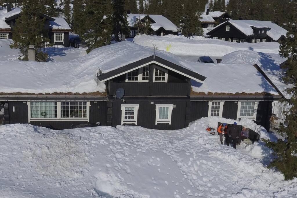 uma casa está coberta de neve em Stor familiehytte på Småsætra, Sjusjøen em Sjusjøen