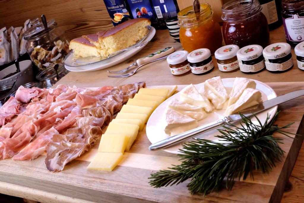 stół z serem, mięsem i innymi produktami spożywczymi w obiekcie Fior Tamion w mieście Vigo di Fassa