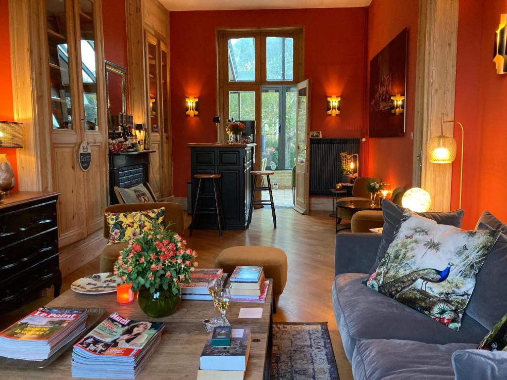 a living room with a couch and a table with books at Les Berges in Bourbourg