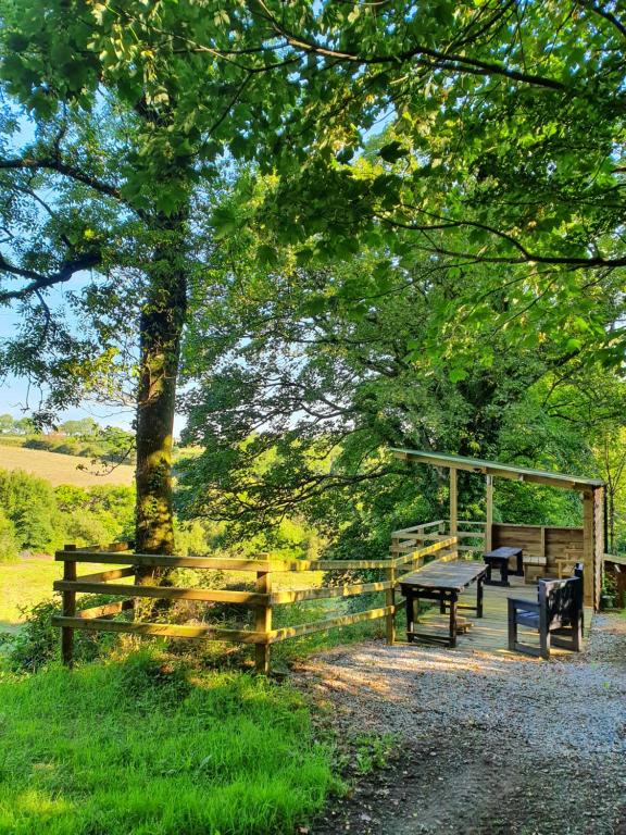 a park with two benches and a picnic table at Villa Muneera - rural retreat in the heart of Pembrokeshire in Narberth