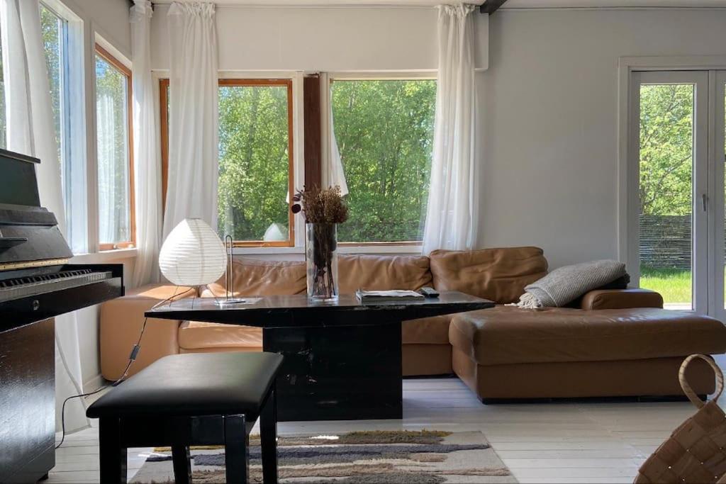 sala de estar con sofá, mesa y piano en Sommerhus i Bjerge Nordstrand tæt ved havet, en Store Fuglede