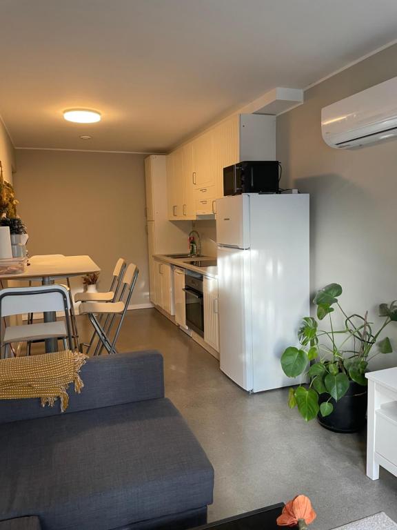 a kitchen with a white refrigerator and a table at Ny Hybel leilighet med eget bad og egen inngang in Moss