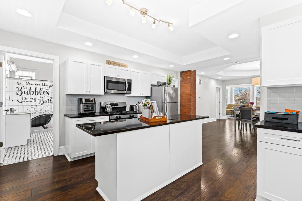 a kitchen with white cabinets and black counter tops at Lovely two-bedroom relaxing private parking Townhome rental in Detroit