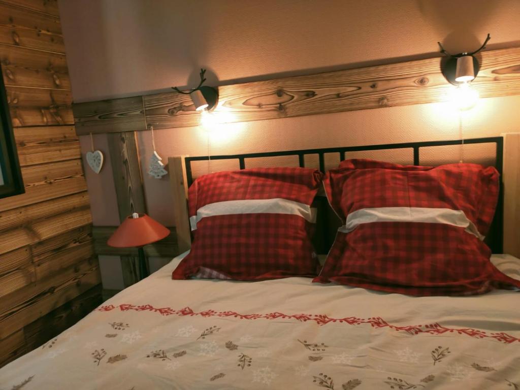 a bedroom with a bed with red and white pillows at Fleurs des Alpes in Les Déserts