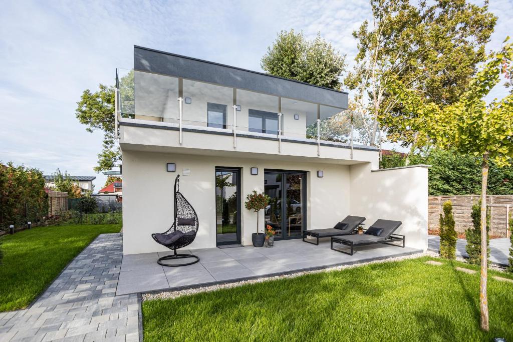 a modern house with a sitting area in a yard at Balatonic Relax in Zamárdi